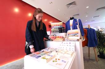 A photograph of a visitor looking at jewellery in the Tate Liverpool + RIBA North shop