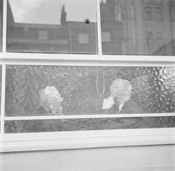 Two heads looking away, seen through a mottled glass window of pub, from the outside looking in
